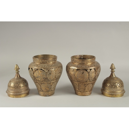 200 - A PAIR OF PERSIAN QAJAR OPENWORKED LIDDED BRASS JARS, decorated with figures and floral motifs, 28cm... 