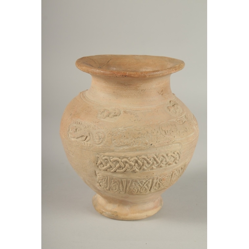 203 - A 10TH CENTURY MIDDLE EASTERN ISLAMIC UNGLAZED POTTERY JUG, with carved calligraphy and animals, 18.... 