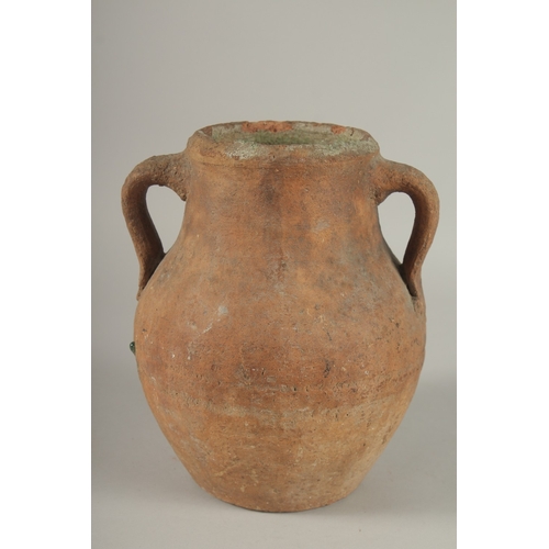 204 - A 10TH CENTURY MIDDLE EASTERN UNGLAZED POTTERY TWIN HANDLE JUG, the interior with traces of green gl... 