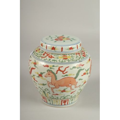 24 - A CHINESE DOUCAI PORCELAIN JAR AND COVER, painted with horses, 16cm high.