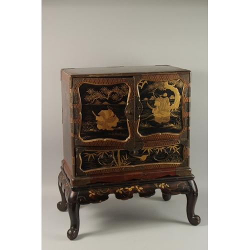 289 - A FINE JAPANESE MEIJI PERIOD BLACK AND GILT LACQUERED CABINET, raised on stand, the two doors openin... 