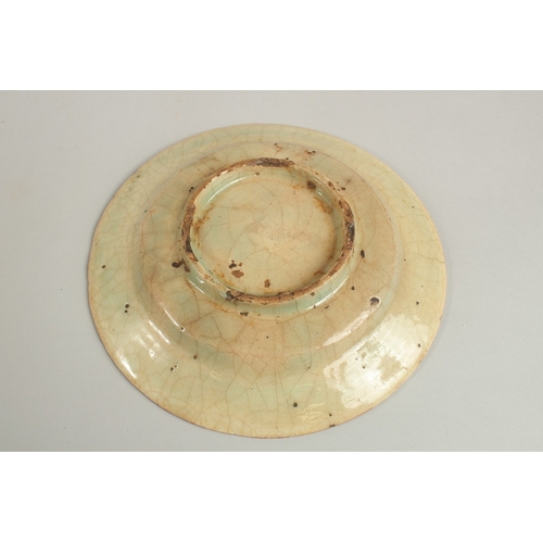 292 - AN EARLY PERSIAN GLAZED POTTERY DISH, painted with foliate designs, 19cm diameter.