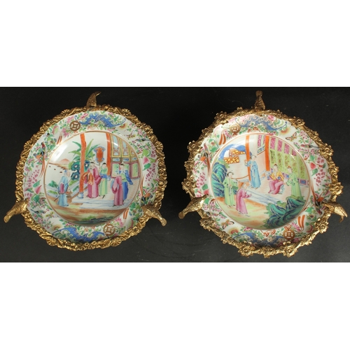 297 - A FINE PAIR OF CHINESE CANTON FAMILLE ROSE PORCELAIN PLATES with gilded metal foliate mounts with bi... 