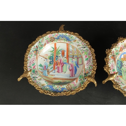 297 - A FINE PAIR OF CHINESE CANTON FAMILLE ROSE PORCELAIN PLATES with gilded metal foliate mounts with bi... 