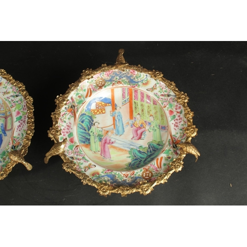 297 - A FINE PAIR OF CHINESE CANTON FAMILLE ROSE PORCELAIN PLATES with gilded metal foliate mounts with bi... 