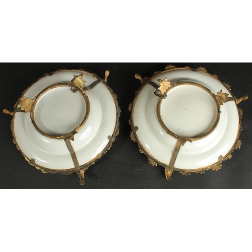 297 - A FINE PAIR OF CHINESE CANTON FAMILLE ROSE PORCELAIN PLATES with gilded metal foliate mounts with bi... 