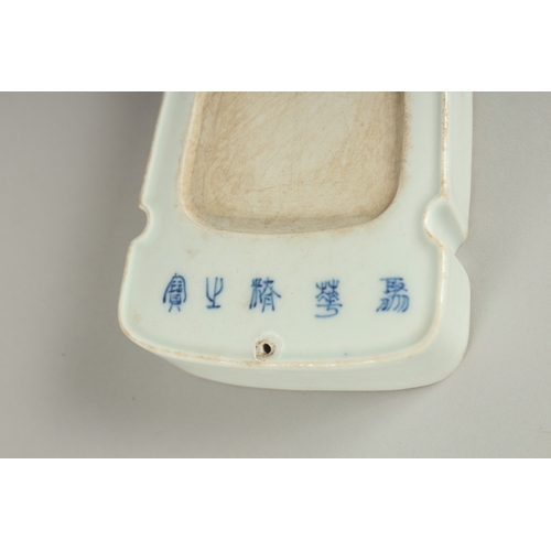 30 - A CHINESE PORCELAIN INKSTONE, with calligraphy inscriptions, 18.5cm long.