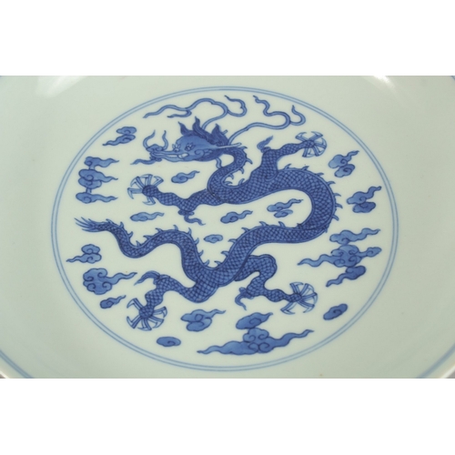 304 - A CHINESE BLUE AND WHITE PORCELAIN DRAGON DISH, with four-character mark, 20cm diameter.