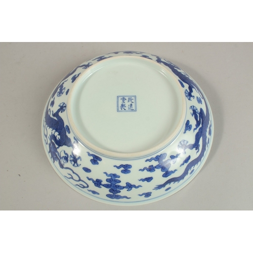 304 - A CHINESE BLUE AND WHITE PORCELAIN DRAGON DISH, with four-character mark, 20cm diameter.