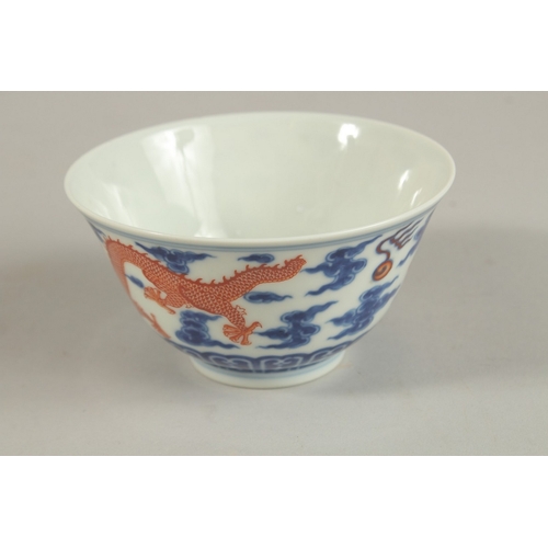 306 - A CHINESE BLUE AND WHITE WITH COPPER RED DRAGON TEA BOWL, six-character mark to base, 11cm diameter.