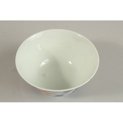 306 - A CHINESE BLUE AND WHITE WITH COPPER RED DRAGON TEA BOWL, six-character mark to base, 11cm diameter.