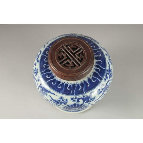 33 - A CHINESE BLUE AND WHITE PORCELAIN JAR AND HARDWOOD COVER, 23cm high.