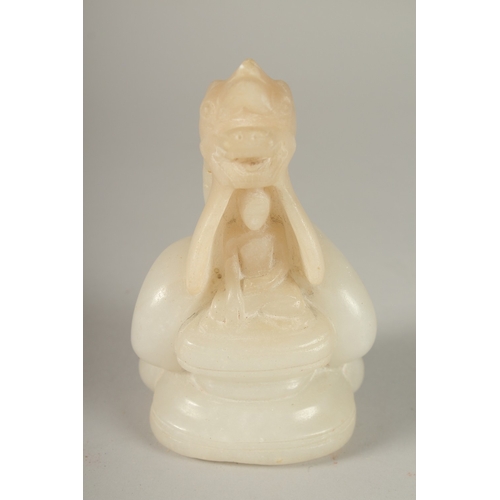 50 - A CARVED ALABASTER BUDDHISTIC FIGURE, with seated buddha and overarching dragon, 14cm high.