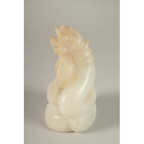 50 - A CARVED ALABASTER BUDDHISTIC FIGURE, with seated buddha and overarching dragon, 14cm high.