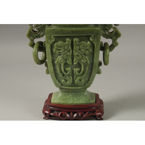 54 - A LARGE CHINESE CARVED GREEN HARDSTONE LIDDED VASE, with twin drop ring handles and carved with dog ... 