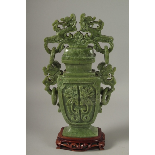 54 - A LARGE CHINESE CARVED GREEN HARDSTONE LIDDED VASE, with twin drop ring handles and carved with dog ... 