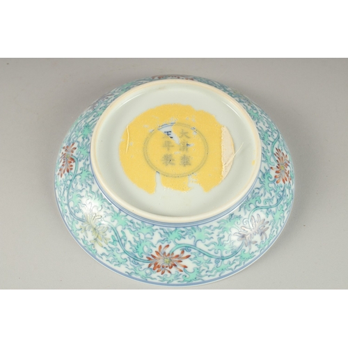 63 - A CHINESE POLYCHROME PORCELAIN FLORAL DISH, the base with six- character mark, 16cm diameter.