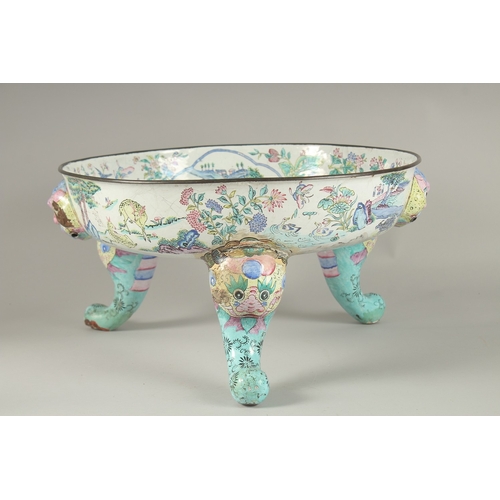 65 - A VERY LARGE CHINESE CANTON ENAMELLED BOWL, raised on curving tripod legs with shaped beast head han... 