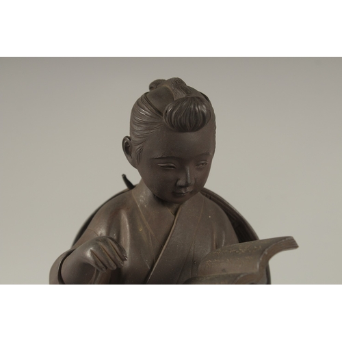 69 - A FINE JAPANESE BRONZE OKIMONO OF A BOY HOLDING A BOOK, signed to the reverse, 31cm high.