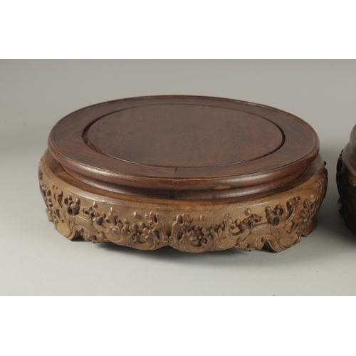 70 - A FINE PAIR OF LARGE CHINESE HARDWOOD CIRCULAR STANDS, each top measuring 26cm diameter.