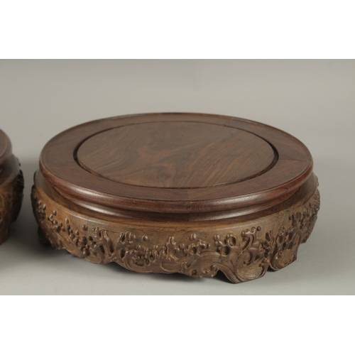 70 - A FINE PAIR OF LARGE CHINESE HARDWOOD CIRCULAR STANDS, each top measuring 26cm diameter.