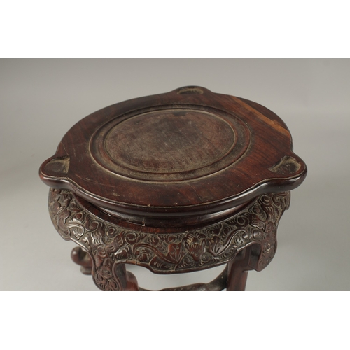 71 - A CHINESE CARVED HARDWOOD STAND, raised on five stretchered legs, the central circular carving desig... 