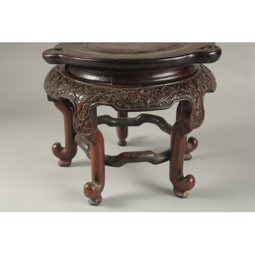 71 - A CHINESE CARVED HARDWOOD STAND, raised on five stretchered legs, the central circular carving desig... 