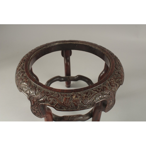 71 - A CHINESE CARVED HARDWOOD STAND, raised on five stretchered legs, the central circular carving desig... 