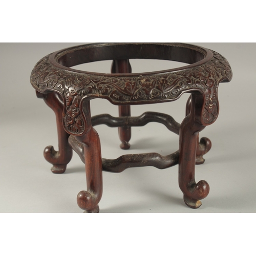 71 - A CHINESE CARVED HARDWOOD STAND, raised on five stretchered legs, the central circular carving desig... 