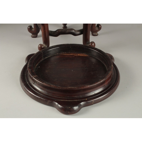 71 - A CHINESE CARVED HARDWOOD STAND, raised on five stretchered legs, the central circular carving desig... 