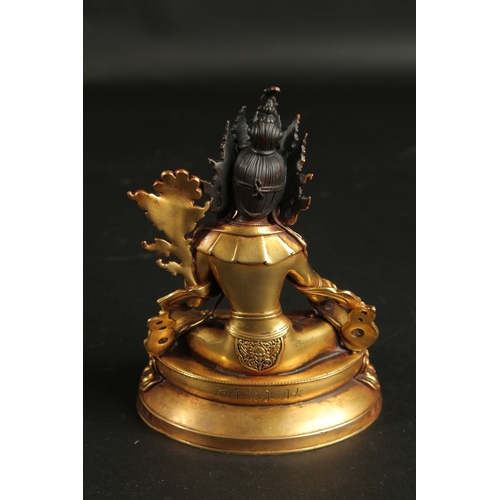 90 - A FINE GILDED BRONZE FIGURE OF A SEATED DEITY, on a lotus base, the reverse inscribed, 15.5cm high.