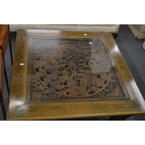 242 - A good large Chinese design hardwood square shaped coffee table, the carved central panel depicting ... 