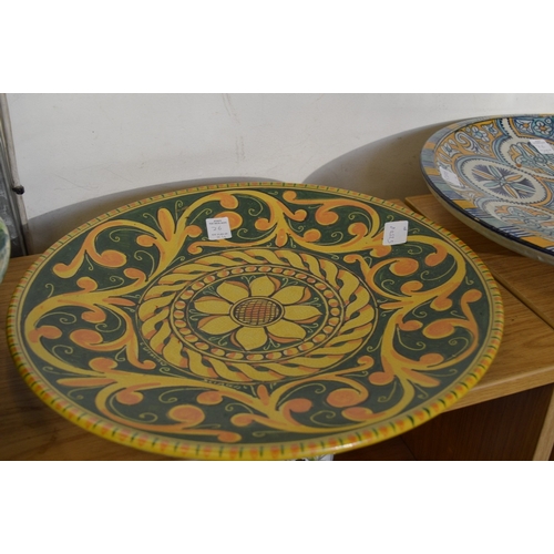 26 - Large colourful fruit bowl and three pottery chargers.