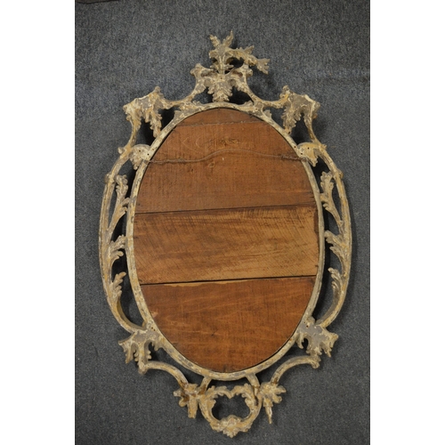 315 - A carved gilt wood oval mirror with pierced frame.