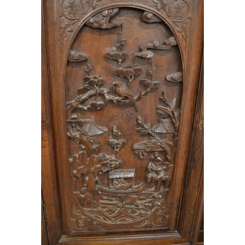 323 - A late 19th century carved hardwood display cabinet with two decoratively carved panel doors, a call... 