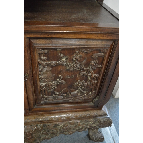 323 - A late 19th century carved hardwood display cabinet with two decoratively carved panel doors, a call... 