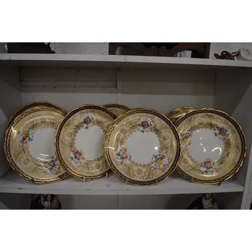 537 - A set of eight Cauldon china cabinet plates with floral decoration and blue and gilt borders.