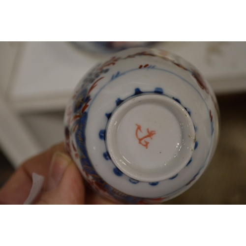 574 - A pair of 19th century cups and saucers and a floral decorated saucer.