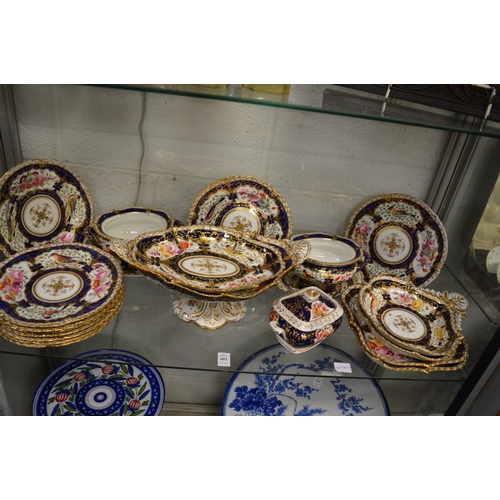 603 - A 19th century porcelain part dinner service, gilt and blue decorated, painted with panels of flower... 