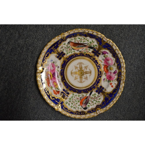 603 - A 19th century porcelain part dinner service, gilt and blue decorated, painted with panels of flower... 