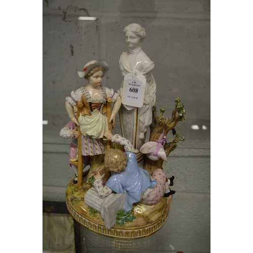 608 - A 19th century porcelain figure group of children by a statue.