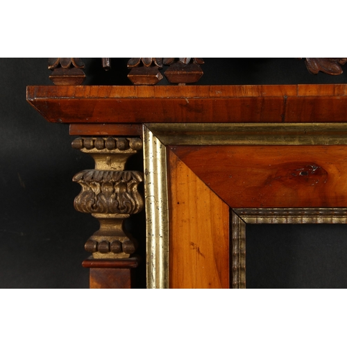 31 - A 19th Century Italian walnut tabernacle frame with carved scrolling top ornament, rebate size 15