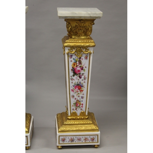 509 - A GOOD PAIR OF PORCELAIN AND ORMOLU MARBLE TOP PEDESTALS, painted with flowers. 4ft 2ins high , the ... 