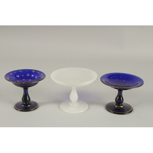 550 - TWO SMALL BLUE GLASS AND GILT DECORATED GLASS TAZZAS, and a similar opaque white glass tazza (3). 10... 