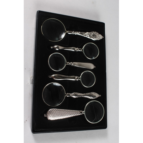 879 - A SET OF SIX VARIOUS MAGNIFYING GLASSES in a case.