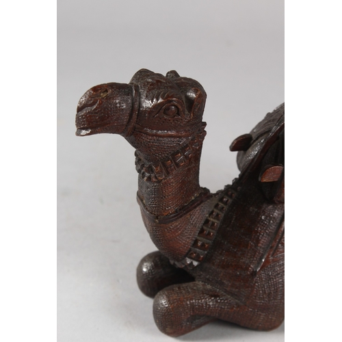 106 - A FINELY CARVED 19TH CENTURY INDIAN WOODEN CAMEL, 20cm long.