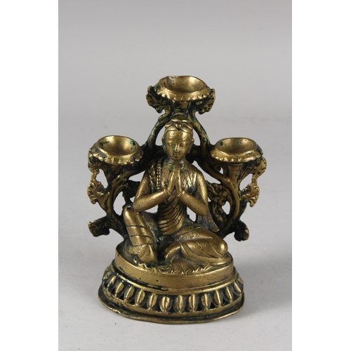 110 - A FINE 17TH CENTURY NEPALESE BRONZE OIL LAMP, with seated deity in the centre, 16cm high.