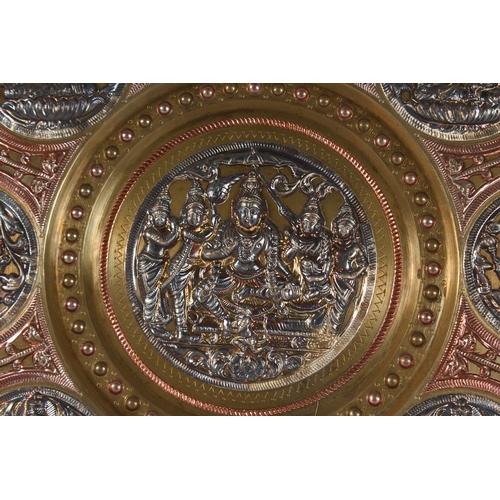 116 - A SOUTH INDIAN TANJORE SILVER AND COPPER OVERLAID BRASS CHARGER, with Hindu deities, 31cm diameter.