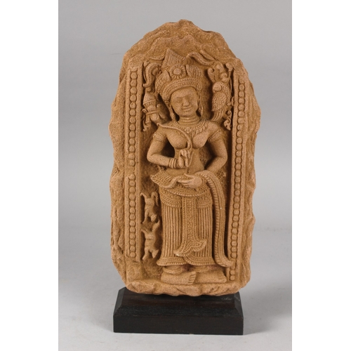 124 - A FINE CAMBODIAN KHMER STYLE PANEL DEPICTING A DEITY, on a wooden stand, 35cm high overall.