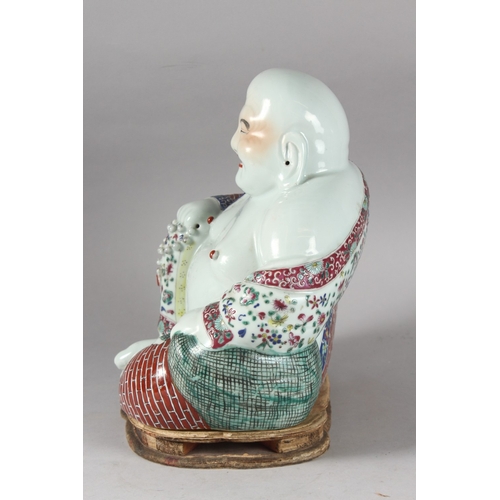 161 - A LARGE CHINESE PORCELAIN LAUGHING BUDDHA, on a shaped stand, the robes painted with flowers and bri... 